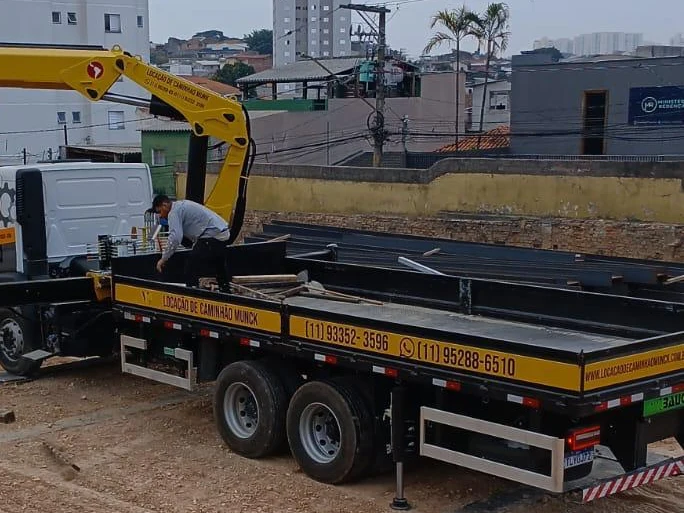 Caminhão munck da CMO içando uma viga em obra